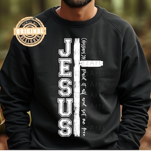 May include: Black sweatshirt with a white graphic of a cross and the word "JESUS" with the text "Colossians 2:14 Paid it all and set me free" underneath.