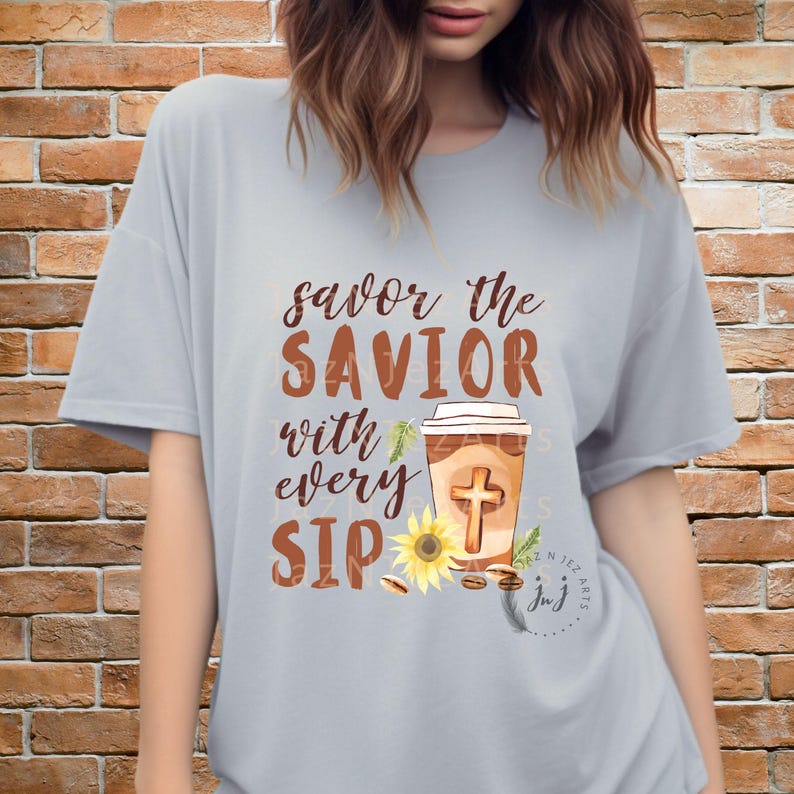 May include: A gray t-shirt with the text "savor the SAVIOR with every SIP" and a graphic of a coffee cup with a cross, a sunflower, and coffee beans.