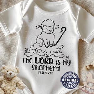 May include: White baby onesie with a black graphic of a sheep on a cloud, a shepherd's crook, and the text "The LORD is my Shepherd Psalm 23:1". The onesie has short sleeves.