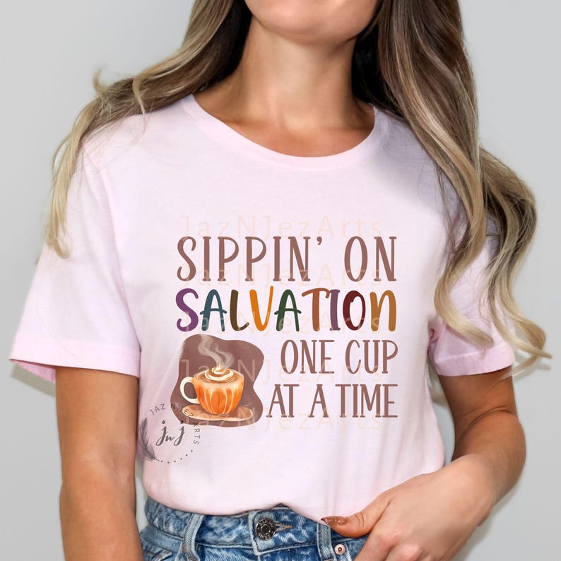 May include: A pink t-shirt with the text "Sippin' on Salvation One Cup at a Time" and a cartoon illustration of a steaming cup of coffee.