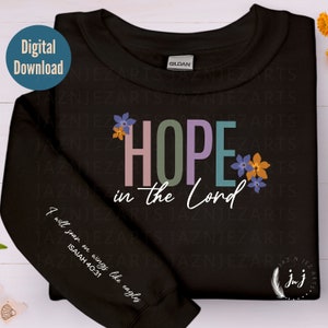 May include: Black sweatshirt with the words "HOPE in the Lord" in colourful letters with floral accents. The left sleeve has the text "I will soar on wings like eagles ISAIAH 40:31" in white.