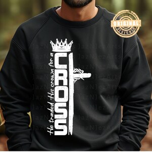 Puede incluir: Sudadera negra con un diseño gráfico blanco de una corona, una cruz y el texto "He traded His crown for a CROSS".