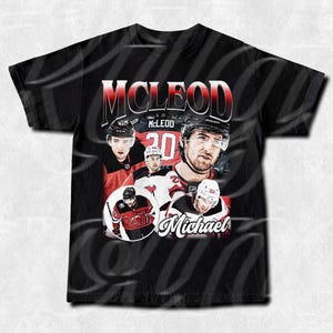Może przedstawiać: Czarny T-shirt z grafiką hokeisty w czerwono-czarnej koszulce z nazwiskiem "MCLEOD" i numerem "20" na plecach. Tekst "Michael" jest napisany pod obrazkiem hokeisty.