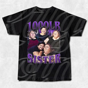 Może przedstawiać: Czarny t-shirt z grupowym zdjęciem pięciu kobiet. Napis "1000LB SISTER" jest wydrukowany na fioletowo u góry i u dołu. Kobiety uśmiechają się i pozują do zdjęcia.