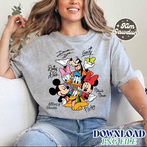 May include: A gray short-sleeved t-shirt featuring a colorful graphic of Disney characters, including Mickey Mouse, Minnie Mouse, Donald Duck, and Goofy. The characters' names are written above or below them in a handwritten style. The text "DOWNLOAD PNG FILE" is at the bottom.