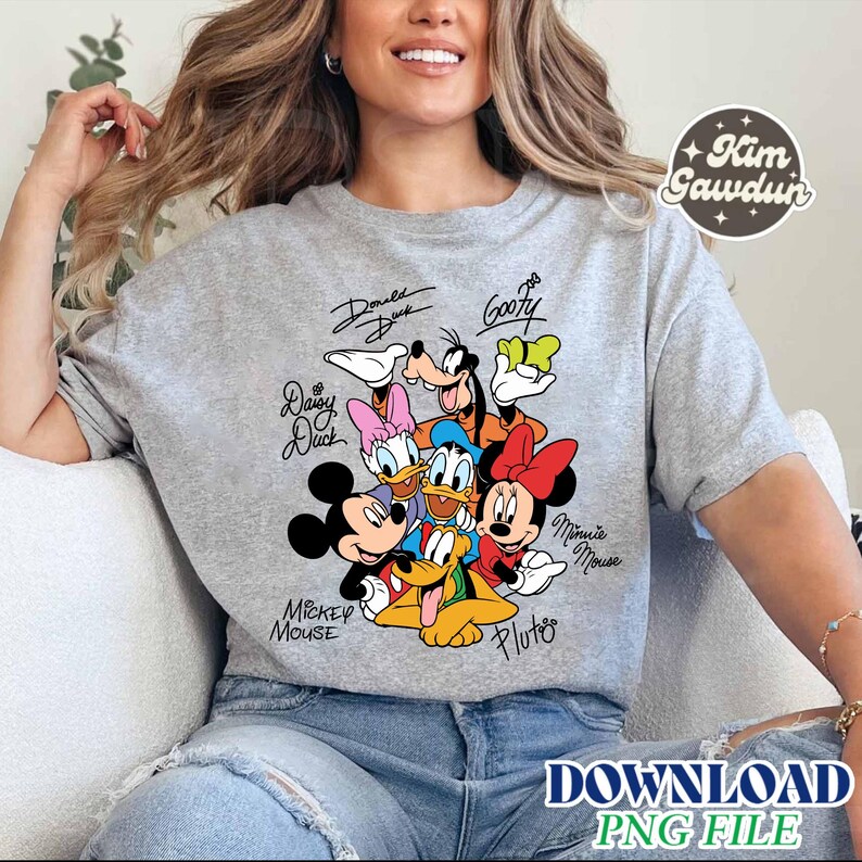 May include: A gray short-sleeved t-shirt featuring a colorful graphic of Disney characters, including Mickey Mouse, Minnie Mouse, Donald Duck, and Goofy. The characters' names are written above or below them in a handwritten style. The text "DOWNLOAD PNG FILE" is at the bottom.