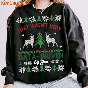 May include: Black sweatshirt with a festive design. The text "THAT WASN'T VERY DATA-DRIVEN Of You" is displayed in red and green. The design includes snowflakes, Christmas trees, and reindeer.