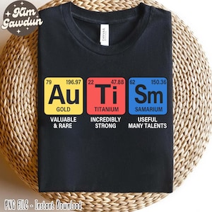 May include: Black t-shirt with three colorful squares featuring the chemical symbols and names for gold, titanium, and samarium. The squares also include the atomic number and atomic weight of each element. Below each square is a description of the element.  The text reads: "Au Gold Valuable & Rare", "Ti Titanium Incredibly Strong", and "Sm Samarium Useful Many Talents".
