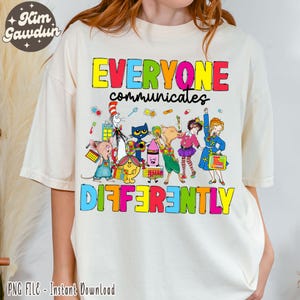 May include: Cream-colored t-shirt featuring the text "EVERYONE communicates DIFFERENTLY" in colorful block letters. Below the text are cartoon characters, including a cat in a hat, a mouse, and a pig. The shirt is a PNG file for instant download.