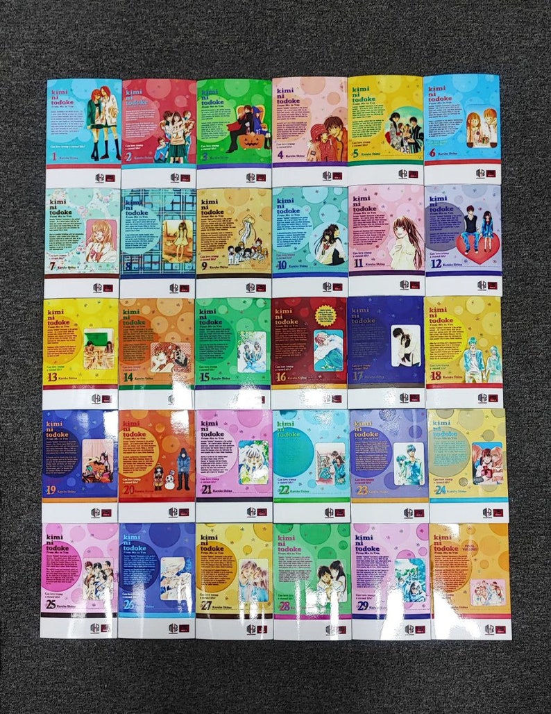 May include: A collection of 29 manga volumes with colorful covers featuring illustrations of characters and text in Japanese. The volumes are arranged in a grid pattern, with the first volume on the left and the last volume on the right.