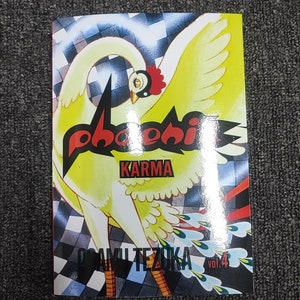 May include: A comic book cover featuring a yellow bird with red and black text that reads "phoenix karma" and "osamu tezuka" with the volume number "vol. 4" in the bottom right corner.