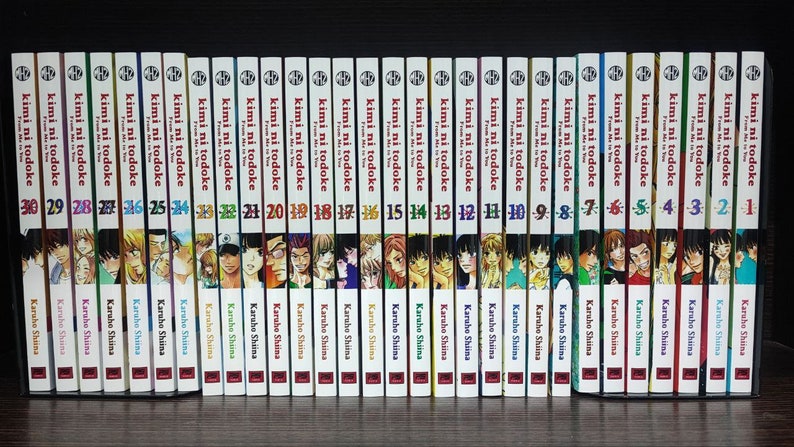 May include: A complete set of 30 manga volumes of "Kimi ni Todoke" by Karuho Shiina. The spines of the books are red, white, and black with the title "Kimi ni Todoke" and the volume number printed on each spine.