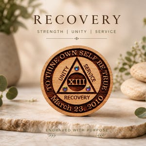 May include: A round wooden token with the word "RECOVERY" at the top and "March 23, 2010" at the bottom. The token has a triangle with the Roman numeral XIII and the words "UNITY" and "SERVICE". The text "TO THINE OWN SELF BE TRUE" is around the edge.