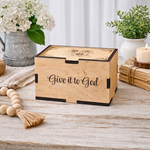 May include: A white ceramic mug with a black handle and the text "But First, Coffee" in a handwritten style. The mug is on a white surface. The mug is 4 inches tall.
