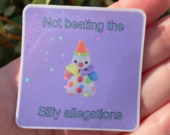 May include: A purple sticker with a glittery background and stars. The sticker features a cartoon clown with a red nose and a colorful outfit. The text on the sticker reads "Not beating the silly allegations."