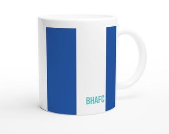 May include: White ceramic mug with blue vertical stripes and the letters BHAFC in teal. The mug has a curved handle and a smooth, glossy finish. The design is simple and modern.