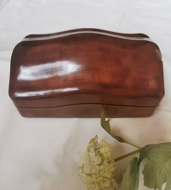 Scatola portagioie in cuoio, mai usata vintage, con forma bombata  , artigianato italiano. All'interno ricoperta in alcantara in colore ecrù