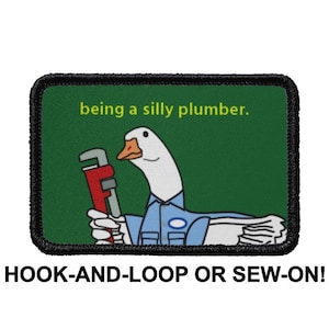 May include: A black and green embroidered patch with a white goose wearing a blue uniform and holding a red wrench. The text "being a silly plumber." is above the goose. The patch is labeled "HOOK-AND-LOOP OR SEW-ON!"