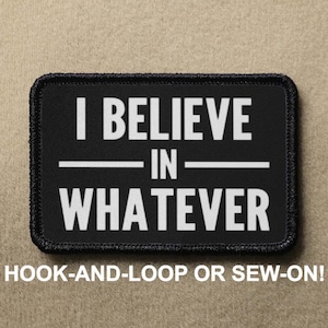 Pode incluir: Patch preto com texto branco que diz "I BELIEVE IN WHATEVER". O patch é para fixação de gancho e laço ou para costurar.