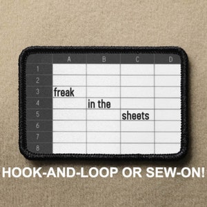 May include: Black and white iron-on patch with a spreadsheet design. The spreadsheet has the words "freak in the sheets" written in the cells. The patch has a black border and says "HOOK-AND-LOOP OR SEW-ON!" at the bottom.