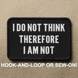 May include: Black patch with white text that reads "I DO NOT THINK THEREFORE I AM NOT". The patch has a black border and is labeled "HOOK-AND-LOOP OR SEW-ON!"