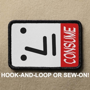 May include: Black and white iron-on patch with a simple emoticon face and the word "CONSUME" in red text. The patch is designed to be sewn or attached with hook-and-loop.