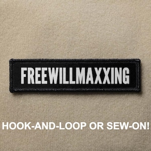 May include: A rectangular black patch with a stitched border featuring the white text FREEWILLMAXXING in a bold sans-serif font. The patch is designed for attachment via a hook-and-loop backing or by sewing it directly onto fabric surfaces.