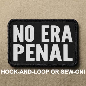 May include: A rectangular black patch with rounded corners and a black stitched border. The patch features the white text NO ERA PENAL in a bold, sans-serif font. The text is arranged in two lines with NO ERA on the top and PENAL on the bottom.