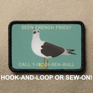 May include: A black and white patch with a cartoon seagull and the text "SEEN FRENCH FRIES? CALL 1-(800)-SEA-GULL". The patch is on a brown background and has a black border.