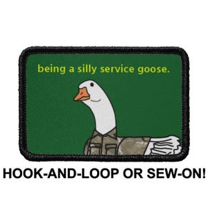 May include: A green and black patch with a cartoon goose wearing a camouflage uniform. The text on the patch reads "being a silly service goose." The patch is labeled "HOOK-AND-LOOP OR SEW-ON!"