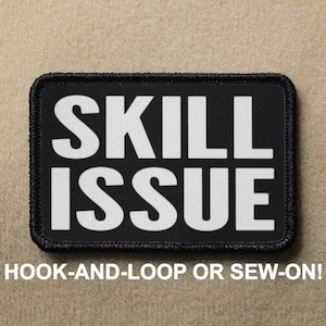 Könnte beinhalten: Schwarzer Patch mit weißem Text, der "SKILL ISSUE" lautet. Der Patch ist so konzipiert, dass er mit Klettverschluss befestigt oder angenäht werden kann.