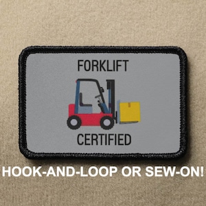 May include: A gray and black rectangular patch with a red forklift graphic and the text "FORKLIFT CERTIFIED". The patch has a hook-and-loop or sew-on option.