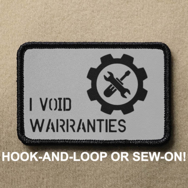 May include: A black and grey patch with a white background. The patch features a gear with a wrench and screwdriver crossed inside. The text "I VOID WARRANTIES" is below the gear.