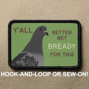 Puede incluir: Un parche bordado verde y negro con una paloma y el texto "Y'ALL BETTER GET BREADY FOR THIS". El parche está diseñado para ser cosido o fijado con velcro.