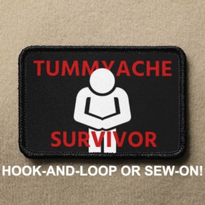 May include: Black and white patch with red text that reads "Tummy Ache Survivor". A white stick figure is in the center of the patch with their hands on their stomach. The patch has black stitching around the edges.