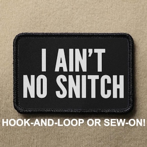 May include: Black patch with white text that reads "I ain't no snitch". The patch is for hook-and-loop or sew-on attachment.