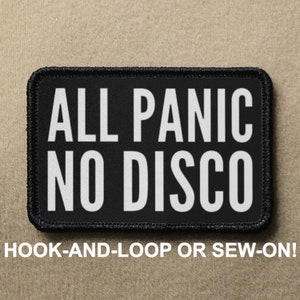 Könnte beinhalten: Schwarz-weiß gestickter Patch mit dem Text "ALL PANIC NO DISCO" in weißen Buchstaben. Der Patch ist zum Anbringen mit Klettverschluss oder zum Annähen gedacht.