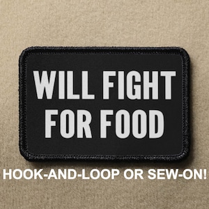 Può includere: Toppa nera con testo bianco che recita "WILL FIGHT FOR FOOD". La toppa ha cuciture nere attorno ai bordi ed è progettata per essere fissata con velcro o cucita.