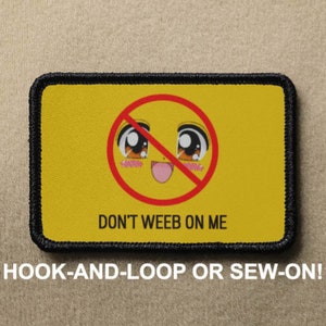 May include: Yellow patch with a red circle and a cartoon anime face with a crossed-out line through it. The text "DON'T WEEB ON ME" is below the circle. The patch has black stitching around the edges.