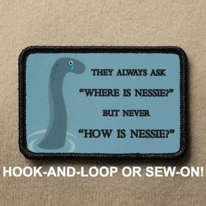 May include: A blue and black embroidered patch with a cartoon illustration of a sad-looking Loch Ness Monster. The text on the patch reads "They always ask "Where is Nessie?" But never "How is Nessie?"  The patch is for hook-and-loop or sew-on attachment.