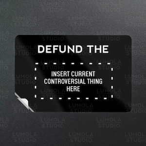 May include: Black and white sticker with the text "DEFUND THE" and a dashed line where you can insert a current controversial thing. The sticker has a peel-off corner.