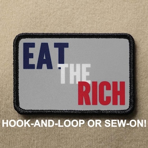 Puede incluir: Un parche bordado gris, negro, blanco y rojo con el texto "EAT THE RICH" en una fuente en negrita y de bloque. El parche está diseñado para ser cosido o fijado con velcro.