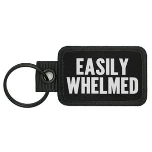 May include: Black key chain with a black rectangular tag that says "EASILY WHELMED" in white text.