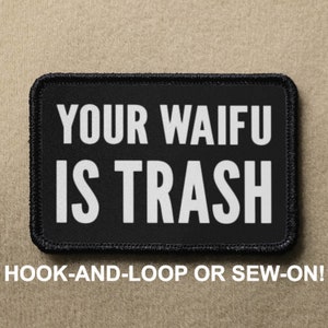 May include: Black patch with white text that reads "YOUR WAIFU IS TRASH". The patch has a black border and is designed to be hooked or sewn onto clothing.