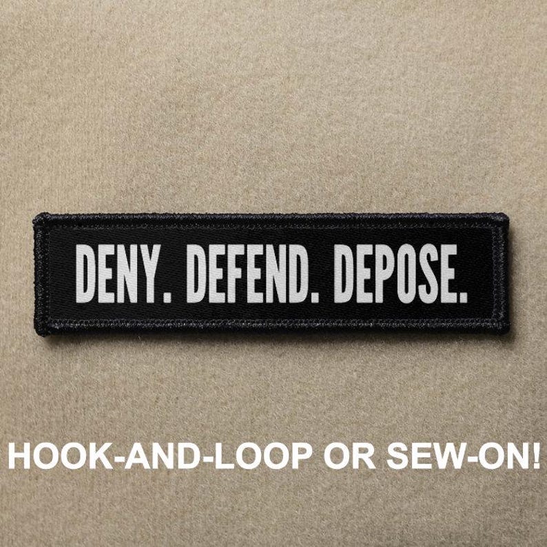 May include: Black and white patch with the text 'DENY. DEFEND. DEPOSE.' The patch has a hook and loop backing and can be sewn on. The patch is displayed on a tan background.