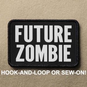 Può includere: Toppa nera con testo bianco che recita "FUTURE ZOMBIE". La toppa ha un bordo nero ed è progettata per essere fissata con velcro o cucita.