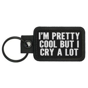 May include: Black key chain with a black rectangular tag that says "I'm pretty cool but I cry a lot" in white text.