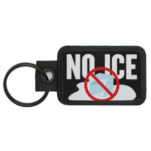 Pode incluir: Chaveiro preto com o texto 'NO ICE' branco e um círculo vermelho com uma linha diagonal que atravessa um cubo de gelo azul.