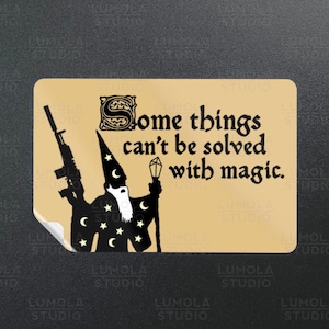 May include: Tan sticker featuring a black silhouette of a wizard holding a rifle and a staff. The sticker has the text "Some things can't be solved with magic."