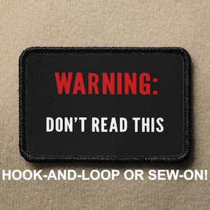 May include: Black patch with white stitching and the text "WARNING: DON'T READ THIS" in red and white lettering. The patch is labeled "HOOK-AND-LOOP OR SEW-ON!"